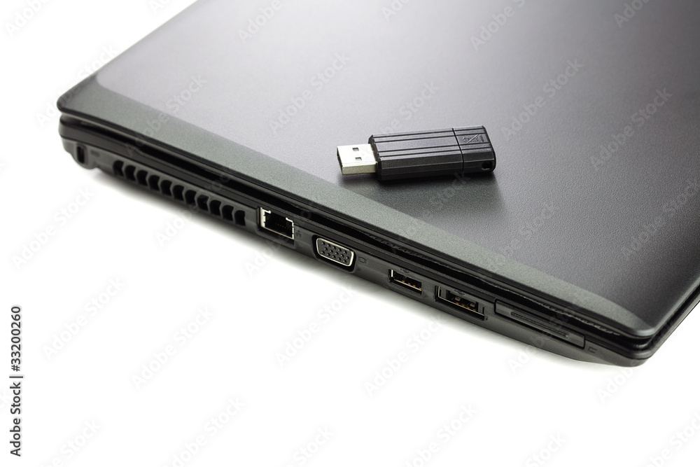 black laptop and flash drive isolated on white black laptop and flash drive isolated on white