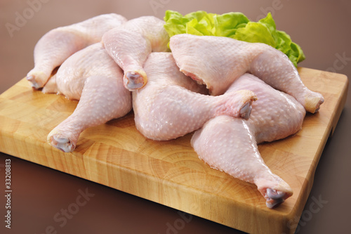 Fresh raw chicken legs arrangement on kitchen cutting board © boguslaw