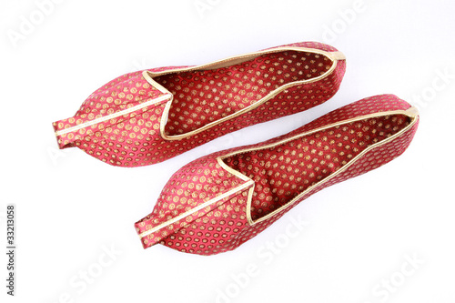 Pair of traditional Indian shoes on white.