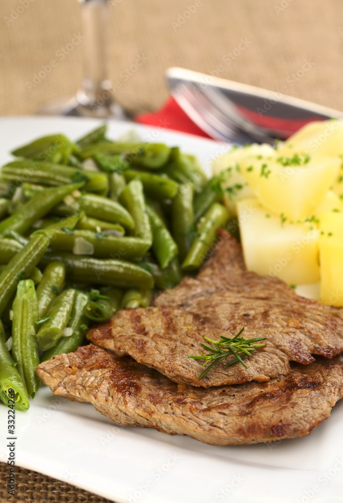 Beef meat slices with potatoes, beans and rosemary