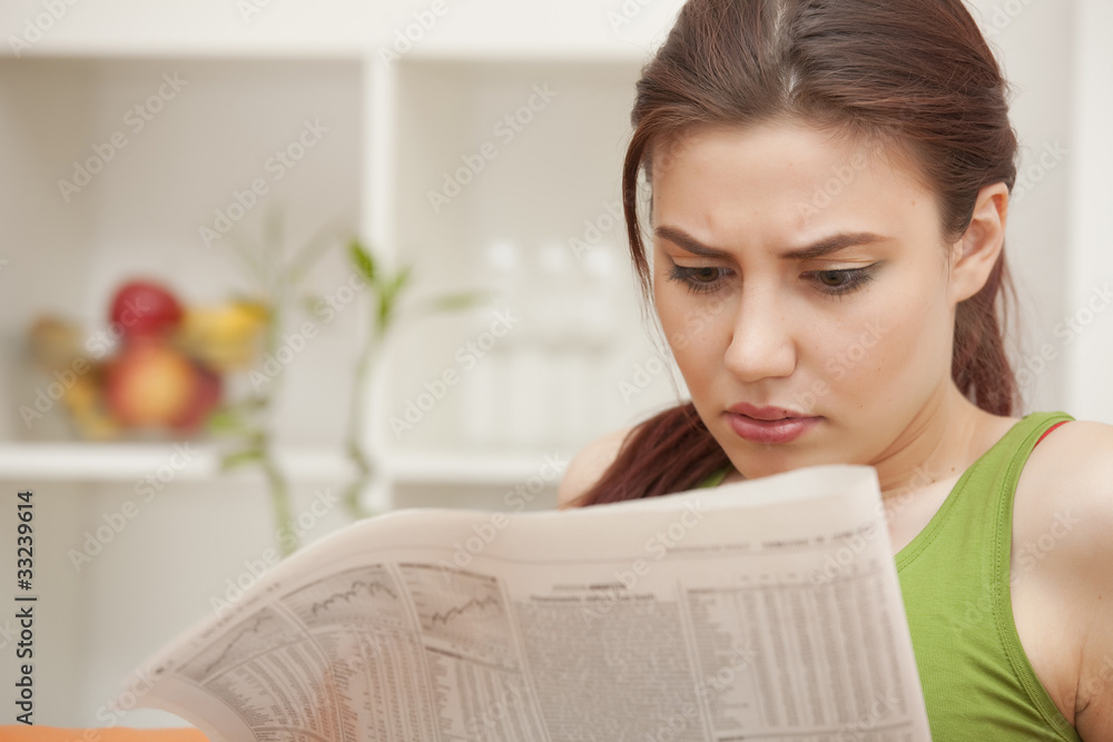 woman reading bad news in newspaper woman reading bad news in newspaper