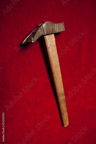 old sledge hammer with wooden handle on a red background