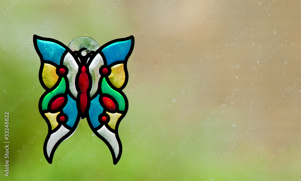 A stained glass butterfly on a rainy window A stained glass butterfly on a rainy window