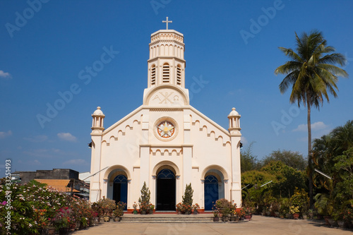 Pastel yellow church against blue sky