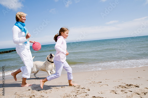 Family playing with dog at the beach