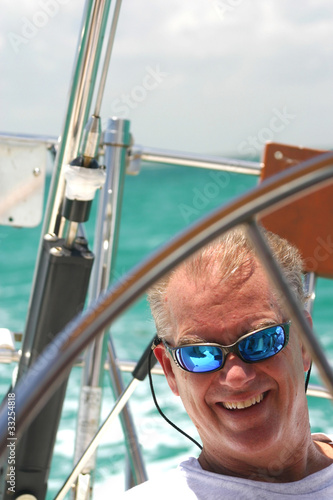 Middle-aged man steering sailboat © mtilghma