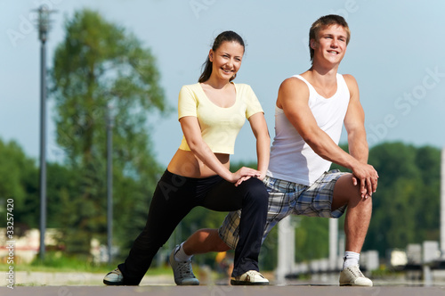 Young man and woman doing stretching exercises