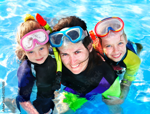Children with mother  in swimming pool.
