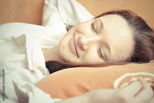 Closeup portrait of young pretty girl laying on her bed