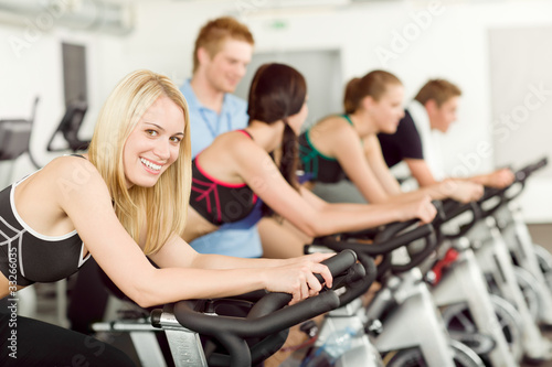 Young fitness people bike spinning with instructor © CandyBox Images