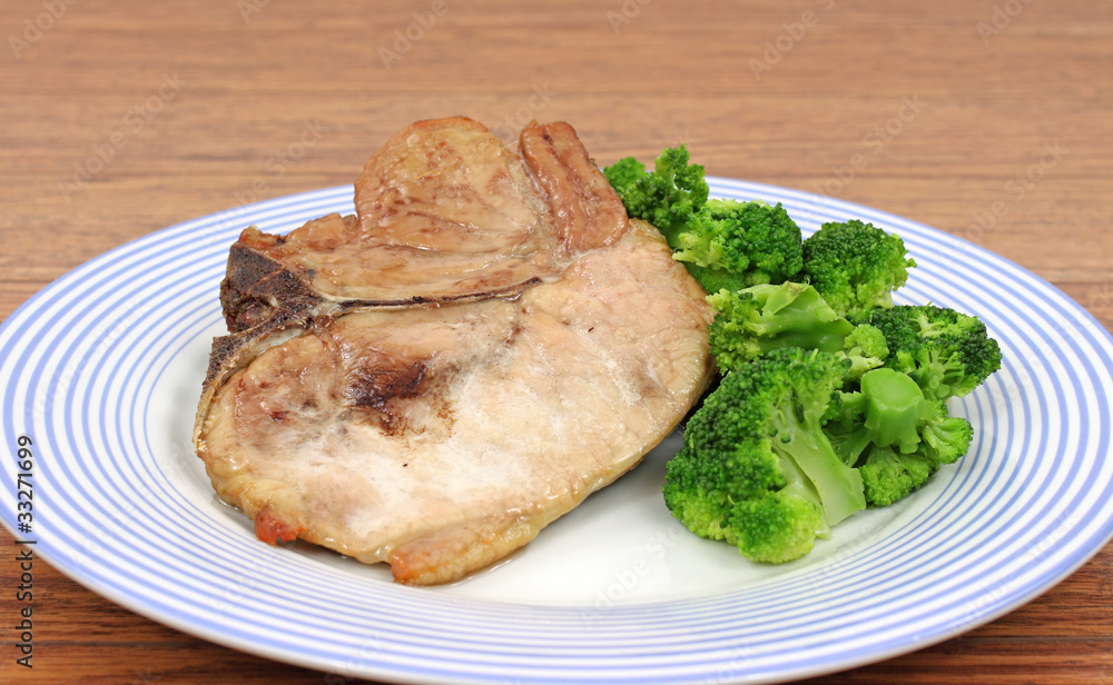Pork chop and broccoli on dish Pork chop and broccoli on dish