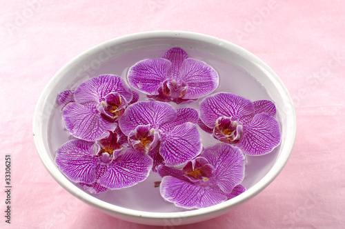 Bowl of spa floating rose in water