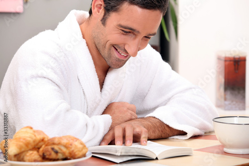 man reading a bookat breakfast