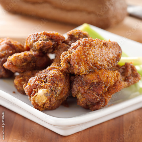 pile of buffalo wings with celery © Joshua Resnick