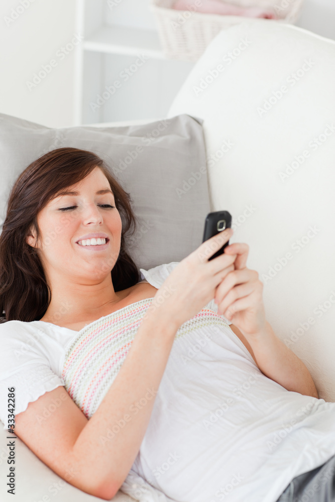 Charming brunette female writing a text on her mobile Charming brunette female writing a text on her mobile