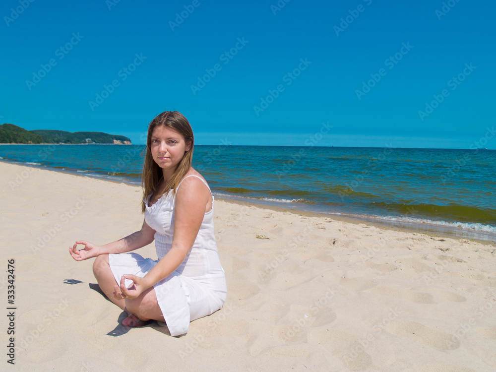 woman practicing yoga on sea beach