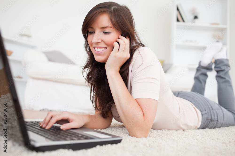 Attractive brunette woman on the phone while relaxing with her l Attractive brunette woman on the phone while relaxing with her l