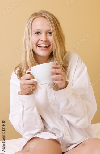 Happy Young Woman Drinking in Casual Attire Upon Waking Up