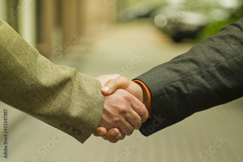 Businesspeople shaking hands, making an agreement.
