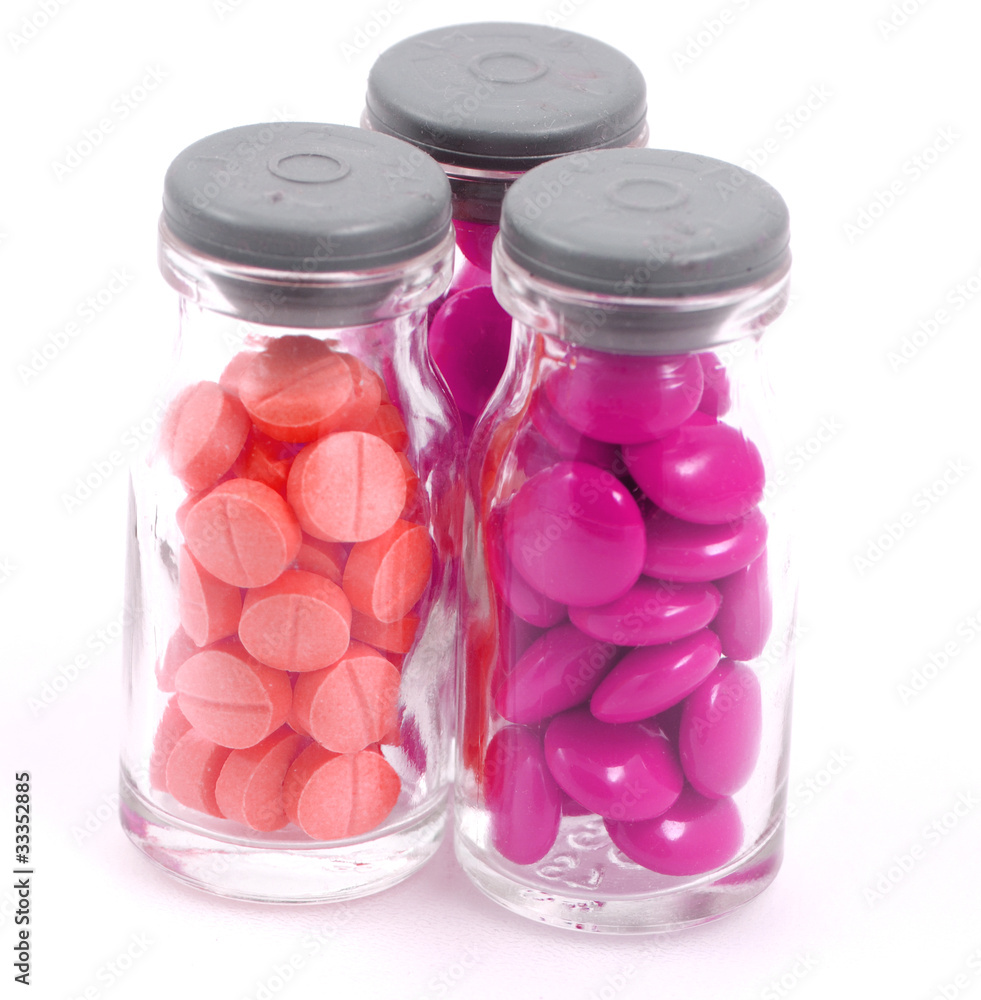Pills in Glass Bottles on White Background Pills in Glass Bottles on White Background