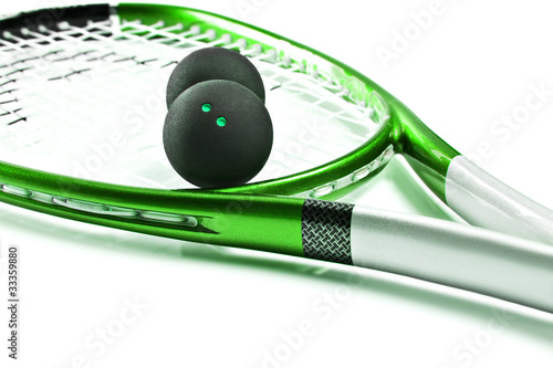 Green squash racket with balls on white