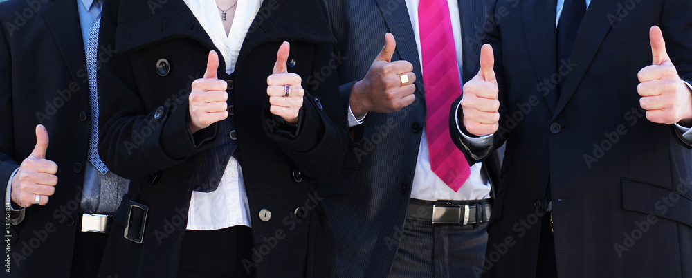 Business people holding thumbs up as a sign of success