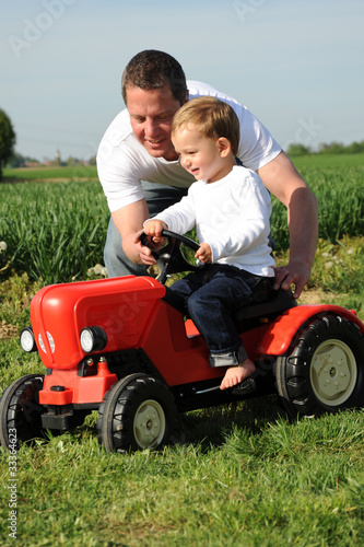 Vater und Sohn mit rotem Traktor