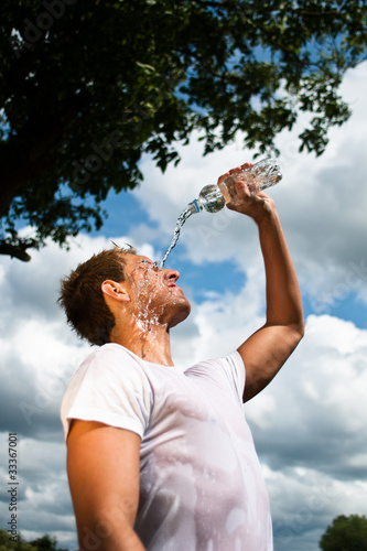 sportsman refreshing himself with a bottle of water