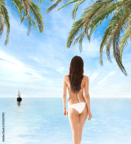 A young and sexy brunette woman on a tropical vacation © Acronym