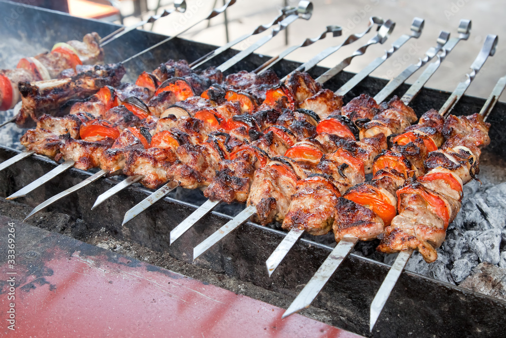Juicy slices of meat with sauce prepare on fire (shish kebab)