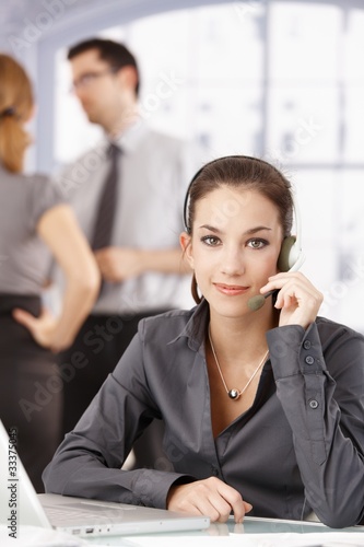 Young customer servicer using headphones in office