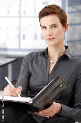 Portrait of businesswoman taking notes