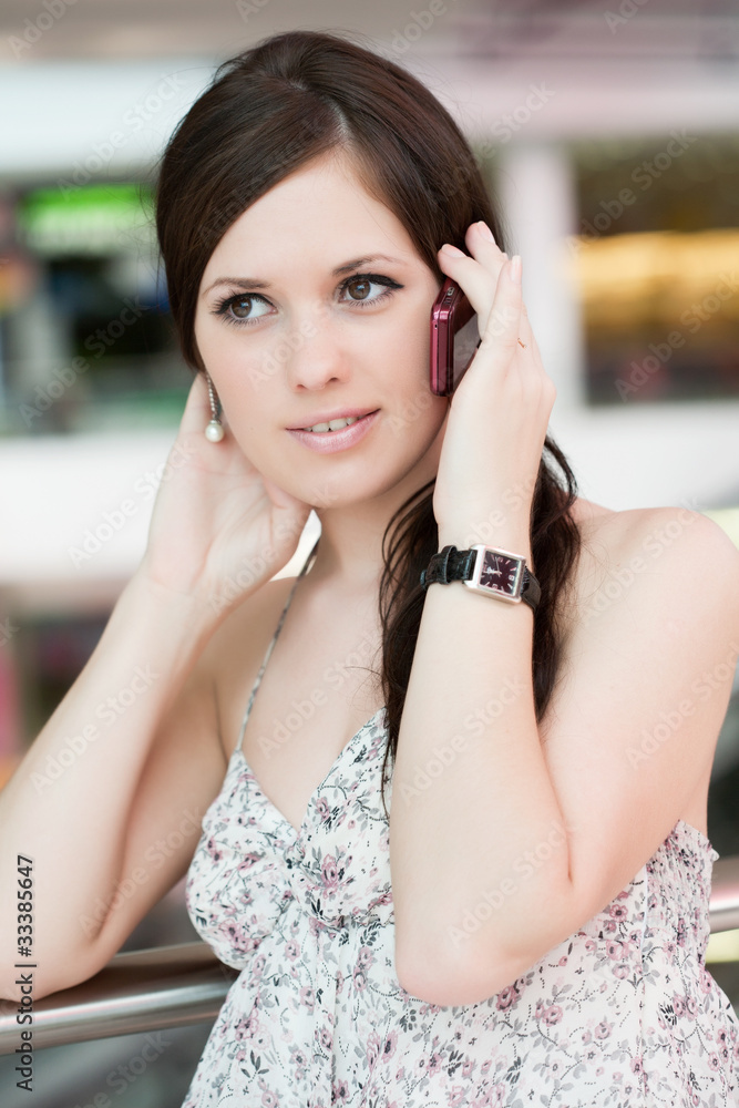 Fototapeta premium beautiful girl speaks by phone in shopping center
