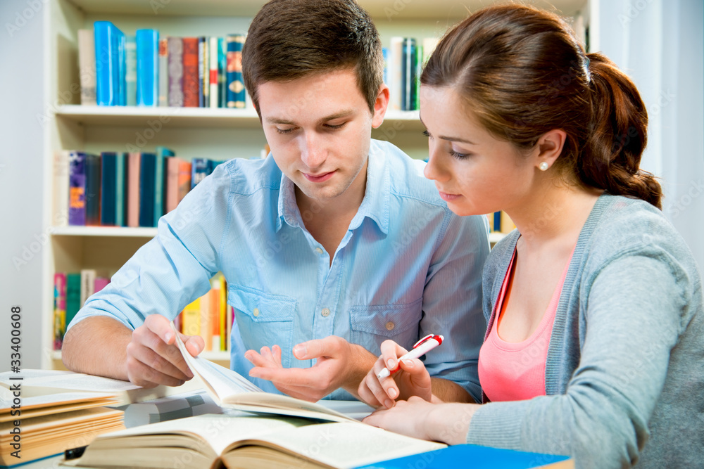 couple of students in a library couple of students in a library