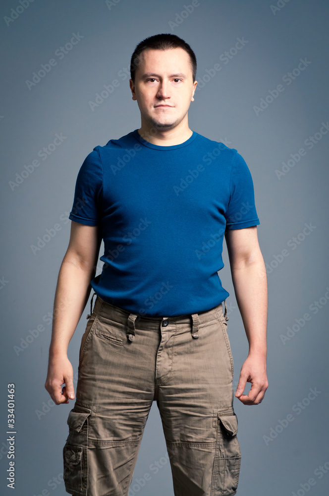 Portrait of an adult man standing with a smirk face Portrait of an adult man standing with a smirk face