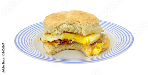 Bitten breakfast sandwich on blue plate