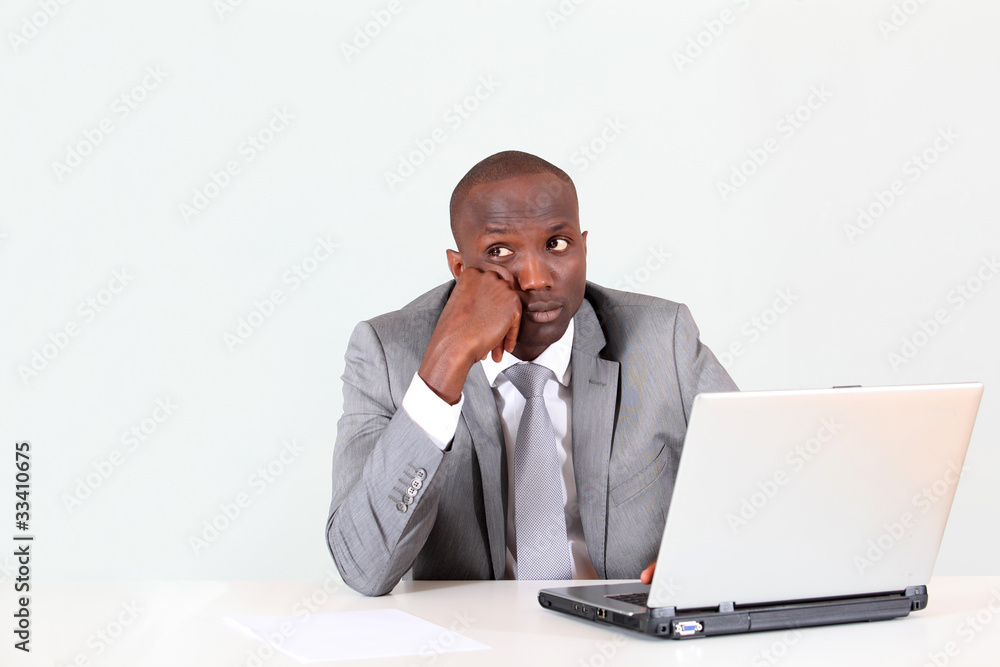 Businessman in office with thoughtful look Businessman in office with thoughtful look