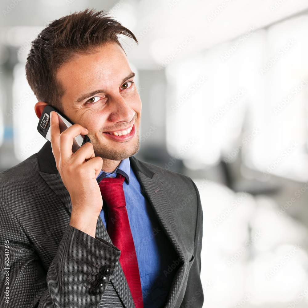 Smiling businessman talking at the phone Smiling businessman talking at the phone