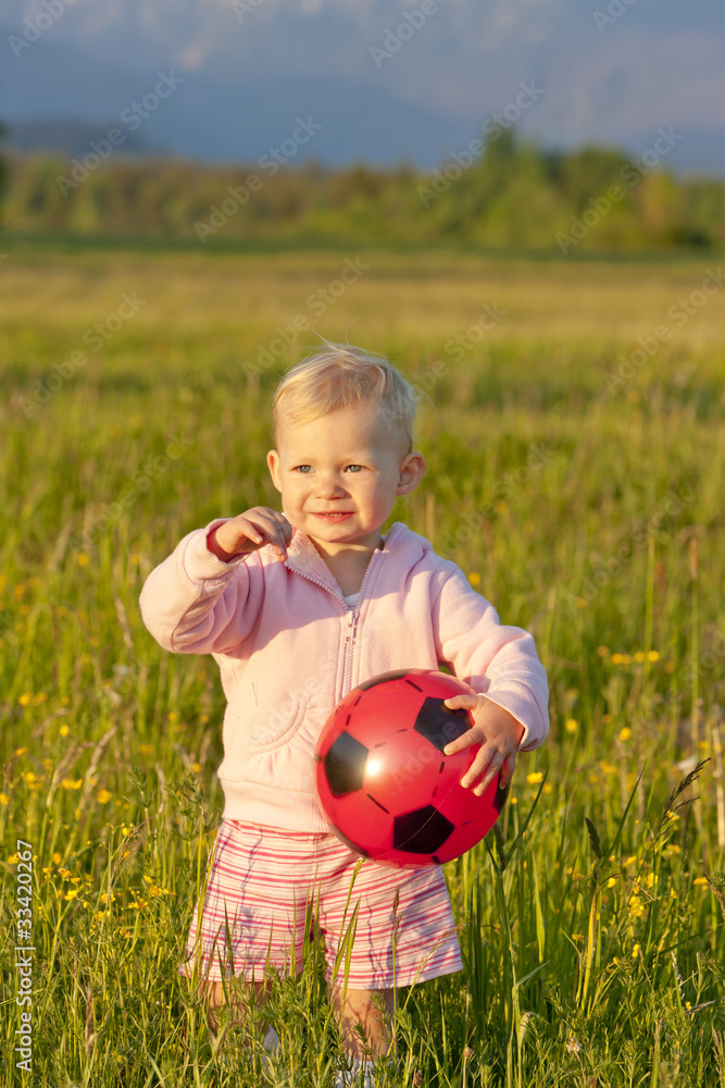 little girl with a ball standing on meadow little girl with a ball standing on meadow