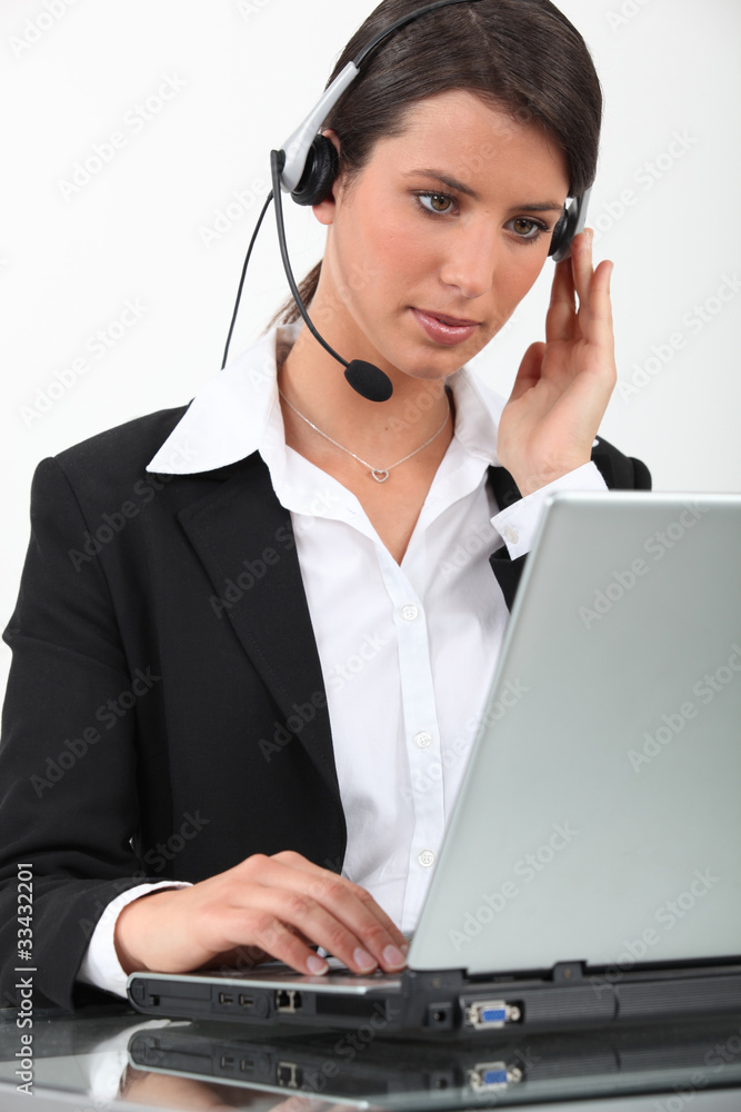 Woman using laptop computer and headset Woman using laptop computer and headset