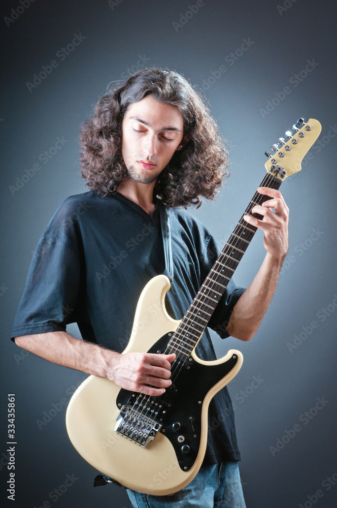 Obraz premium Guitar player against the dark background