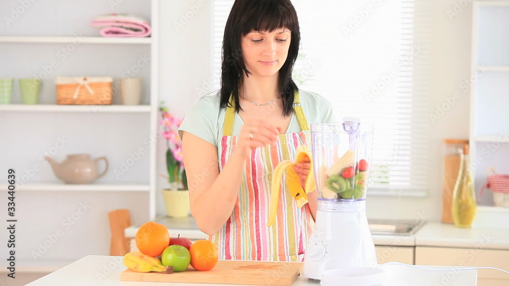 Dark-haired woman preparing a smoothie Dark-haired woman preparing a smoothie