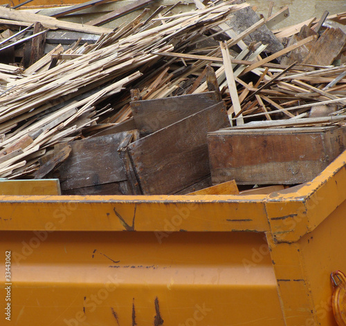 metal orange container filled with wood timber rubble