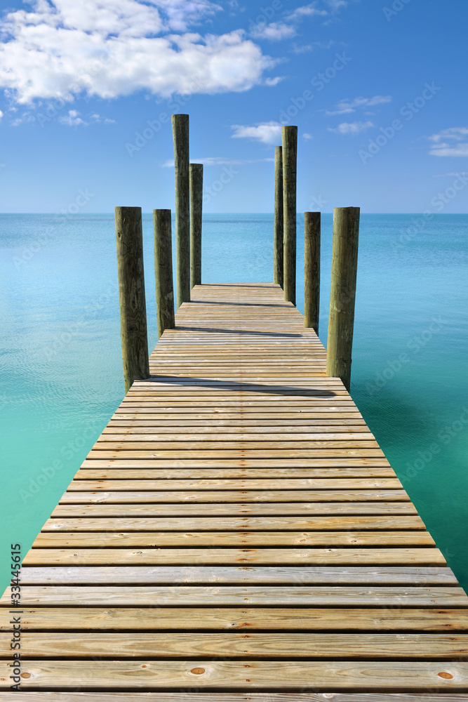 Wooden jetty leading in turquoise blue sea in Governor's Harbour