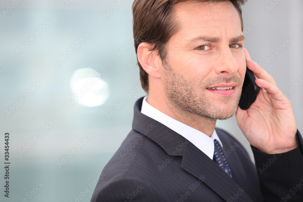 Businessman holding mobile telephone serious expression