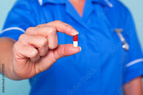 Nurse holding a pill