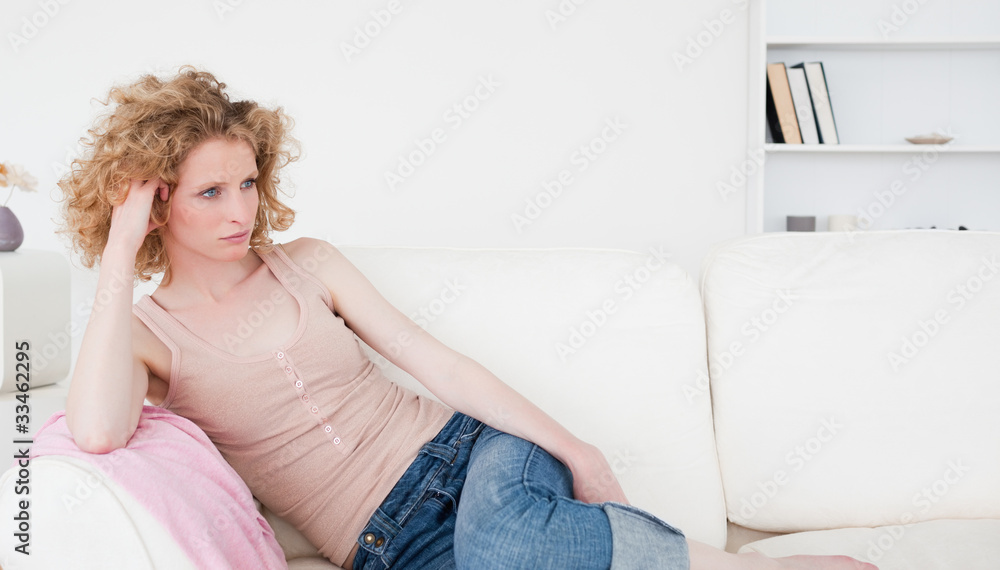 Attractive blonde woman relaxing while sitting on a sofa Attractive blonde woman relaxing while sitting on a sofa