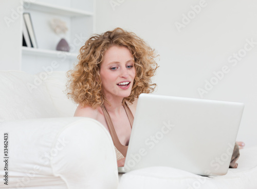 Smiling blonde female relaxing with her laptop while sitting on Free Download Smiling blonde female relaxing with her laptop while sitting on - GFXLoad
