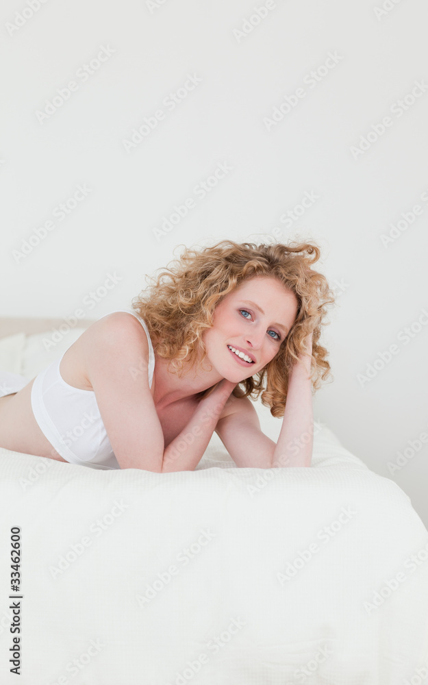 Fototapeta premium Lovely blonde woman relaxing while lying on her bed