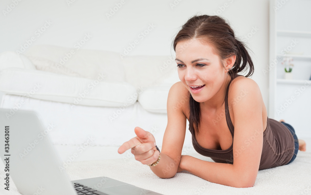 Cute woman pointing at the screen of her laptop Cute woman pointing at the screen of her laptop
